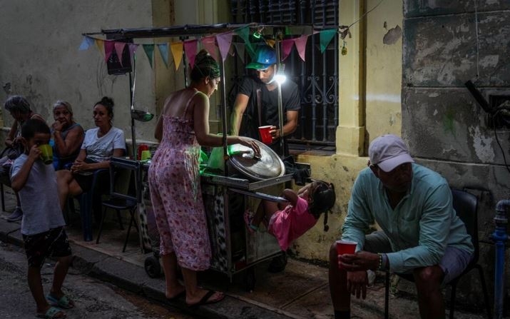 Una mujer compra sopa a un vendedor ambulante durante un apagón en La Habana el 21 de octubre de 2024. (Ramon Espinosa/AP Photo)