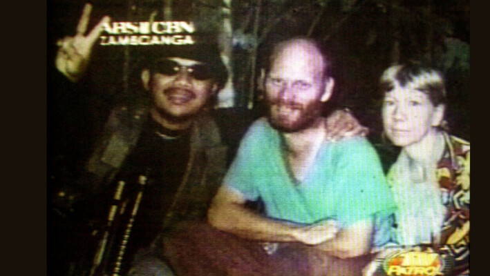 Los misioneros estadounidenses Martin (C) y Gracia Burnham (D), que fueron secuestrados en un centro turístico de Filipinas hace ocho meses, aparecen junto a su secuestrador Abu Sabaya, líder del grupo terrorista Abu Sayyaf, en esta foto sin fechar tomada de un vídeo. (ABS CBN vía AP). 