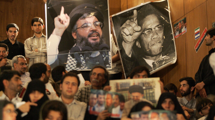 Estudiantes iraníes sostienen carteles del líder libanés de Hezbolá, Hassan Nasrallah, mientras escuchan un discurso del presidente de Nicaragua, Daniel Ortega, en la Universidad de Teherán, el 10 de junio de 2007. (ATTA KENARE/AFP via Getty Images)