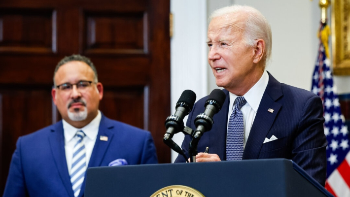 El presidente Joe Biden es acompañado por el secretario de Educación Miguel Cardona mientras anuncia nuevas acciones después de que la Corte Suprema anulara su plan de condonación de préstamos estudiantiles, en la Sala Roosevelt de la Casa Blanca, el 30 de junio de 2023. (Chip Somodevilla/Getty Images)