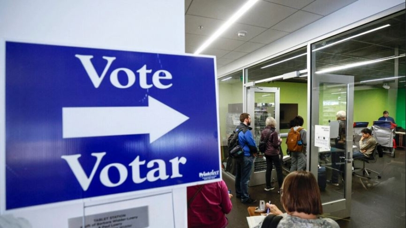 Primeros votantes esperan en fila para emitir su voto en un centro de votación anticipada en la Biblioteca Pública de Madison-Central en Madison, Wisconsin, el 22 de octubre de 2024. (Kamil Krzaczynski/AFP vía Getty Images)