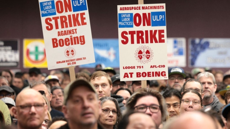 Un grupo de personas sostiene pancartas durante una concentración de huelga de la Asociación Internacional de Maquinistas y Trabajadores Aeroespaciales (IAM) en el Seattle Union Hall de Seattle el 15 de octubre de 2024. (Jason Redmond/AFP vía Getty Images)