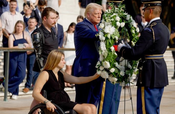 El expresidente Donald Trump deposita una corona de flores junto al cabo Kelsee Lainhart (retirado) y el sargento Tyler Vargas-Andrews (retirado), heridos en el atentado de Abbey Gate en Afganistán, en ceremonia de Tumba del Soldado Desconocido en Arlington, Virginia, el 26 de agosto. (Anna Moneymaker/Getty Images)