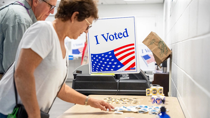 Una mujer elige una pegatina después de votar en el primer día de votación anticipada en persona en el Centro Acuático y de Fitness de Long Bridge Park en Arlington, Virginia, el 20 de septiembre de 2024. (Andrew Harnik/Getty Images)