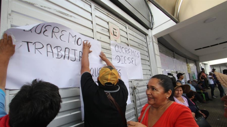 Transportistas pegan carteles durante una protesta en las oficinas de Impuestos Nacionales (SIN), el 24 de octubre de 2024, en Santa Cruz, (Bolivia). EFE/ Juan Carlos Torrejón