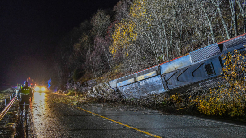 Un agente de policía camina cerca de los vagones de un tren de pasajeros en Finneidfjord, en Nordland, Noruega, a última hora del 24 de octubre de 2024, después de que el tren que transportaba a 55 pasajeros descarrilara tras un corrimiento de tierras, causando un muerto y cuatro heridos a bordo. (Paul-Egil Henriksen/NTB/AFP vía Getty Images)