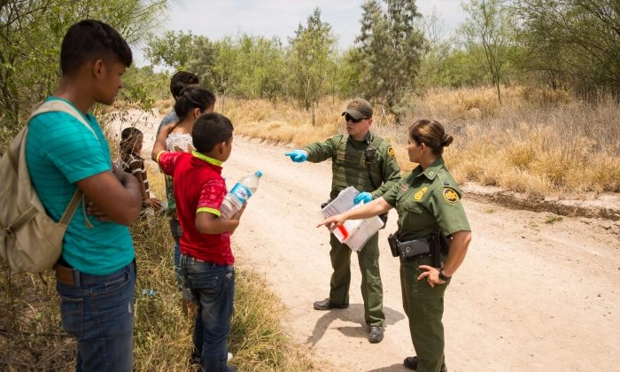 Agentes de la Patrulla Fronteriza hablan con menores no acompañados y otros solicitantes de asilo justo después de cruzar la frontera suroeste en el Valle del Río Grande, Texas, el 26 de mayo de 2017. (Benjamin Chasteen/The Epoch Times)
