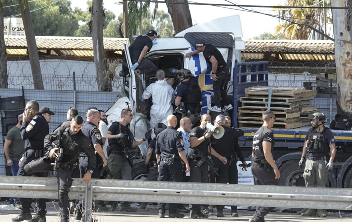 La policía israelí se sube a un camión que se estrelló contra una parada de autobús cerca de la sede de la agencia de espionaje israelí Mossad, en Tel Aviv, Israel, el 27 de octubre de 2024. (Oded Balilty/AP Photo)