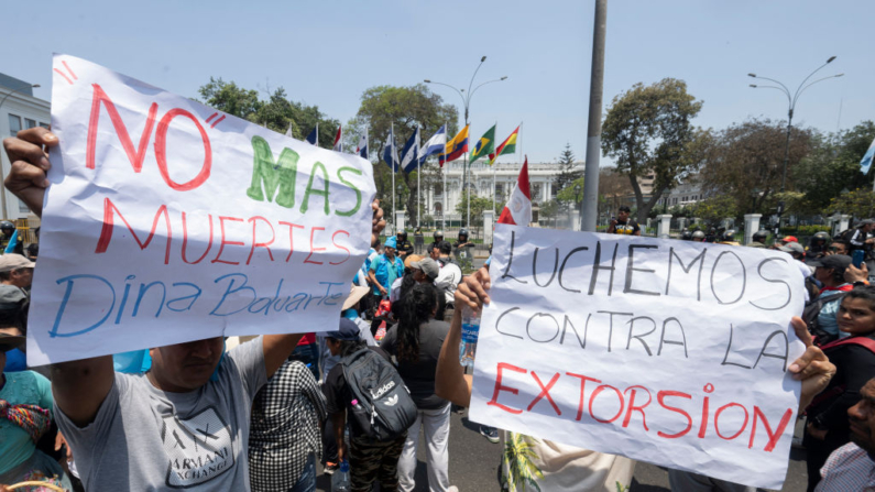 Los manifestantes sostienen carteles y gritan consignas frente al edificio del Congreso en Lima (Perú) durante una huelga convocada por trabajadores y comerciantes del transporte el 23 de octubre de 2024, exigiendo medidas del gobierno contra una creciente ola de extorsión y asesinatos por parte del crimen organizado. (Cris Bouroncle/AFP vía Getty Images)