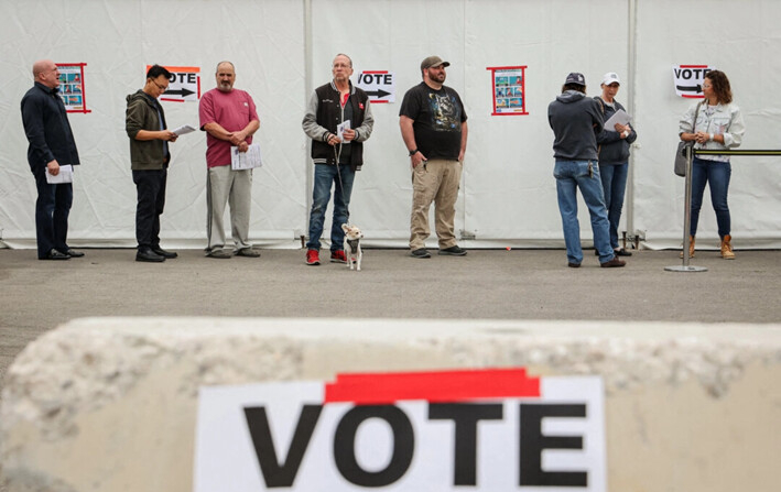 Los carteles de campaña se muestran cerca de los votantes que esperan en la fila en el centro de votación de Las Vegas Athletic Club el día de las elecciones, en Las Vegas, el 8 de noviembre de 2022. (Ronda Churchill/Getty Images)