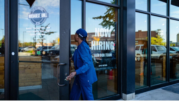 Una mujer entra en un restaurante con un cartel de "Se está contratando" en Royal Oak, Michigan, el 12 de octubre de 2024. (Madalina Vasiliu/The Epoch Times)