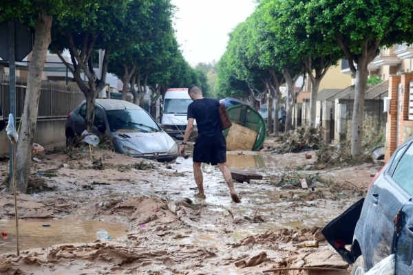 Un hombre camina por una calle cubierta de barro en una zona inundada en Picanya, cerca de Valencia, este de España, el 30 de octubre de 2024. (José Jordan/AFP via Getty Images)