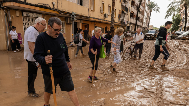 La gente camina por un tramo cubierto de barro después de que las inundaciones azotaran gran parte del país el 31 de octubre de 2024 en el municipio de Paiporta de Valencia, España. (David Ramos/Getty Images)