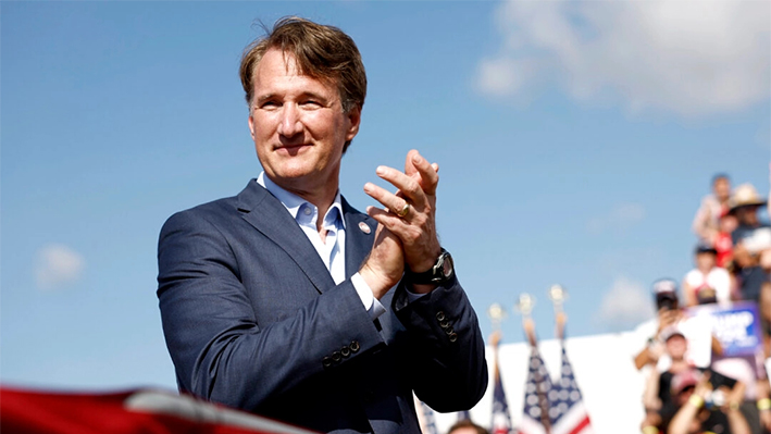 El gobernador de Virginia, Glenn Youngkin, escucha mientras el candidato presidencial republicano, el expresidente Donald Trump, habla durante un mitin en Greenbrier Farms en Chesapeake, Virginia, el 28 de junio de 2024. (Anna Moneymaker/Getty Images)