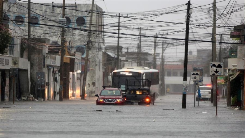 Imagen de archivo de vehículos que transitan por una calle inundada debido a las lluvias provocadas por el paso de un huracán, en Cancún (México). EFE/ Alonso Cupul