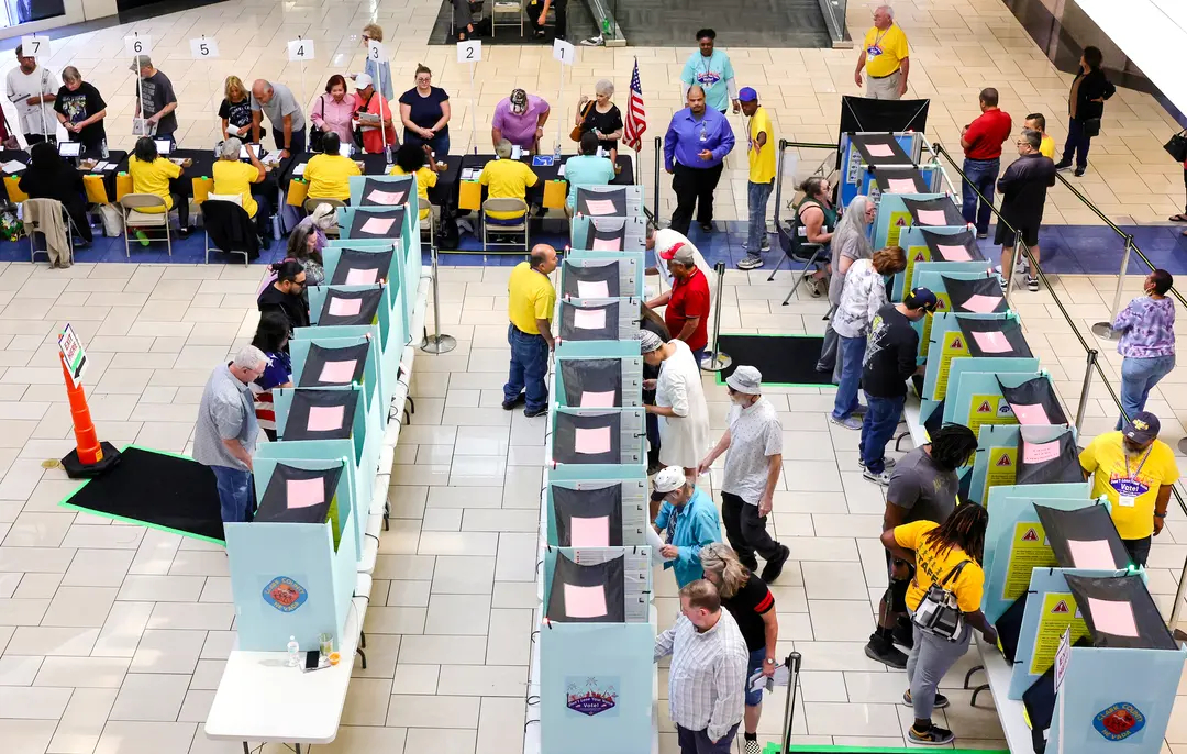 Trabajadores electorales del Departamento Electoral del Condado de Clark registran a los votantes en una mesa mientras la gente vota en el Meadows Mall de Las Vegas el 21 de octubre de 2024. (Ethan Miller/Getty Images)