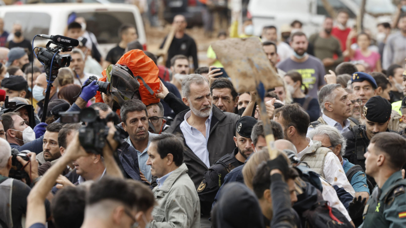 El rey Felipe (c), junto al presidente de la Generalitat de Valencia, Carlos Mazón (c-i), durante su visita a Paiporta este domingo. Gritos de 'fuera', así como lanzamiento de barro, están recibiendo a la comitiva de los reyes de España, el presidente del Gobierno, Pedro Sánchez, y el president de la Generalitat, Carlos Mazón, a su llegada al centro de Paiporta.EFE/ Biel Aliño