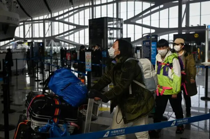 Pasajeros se preparan para registrarse en el aeropuerto internacional de Daxing, en Beijing, el 19 de enero de 2023. (Wang Zhao/AFP vía Getty Images)