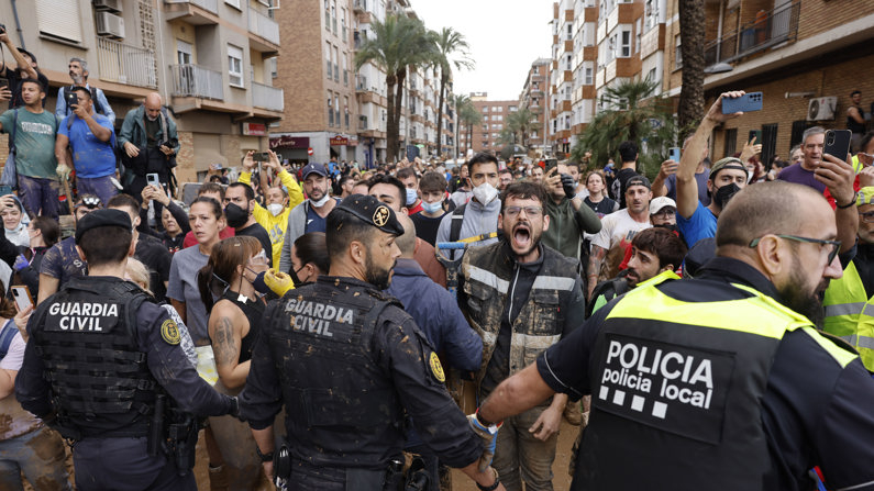 Vecinos indignados gritan insultos durante la visita de la comitiva de los reyes y Sánchez a Paiporta este domingo. Gritos de "fuera", así como lanzamiento de barro, recibieron a la comitiva de los reyes de España, el presidente del gobierno, Pedro Sánchez, y el president de la Generalitat, Carlos Mazón, a su llegada al centro de Paiporta. (EFE/ Ana Escobar)