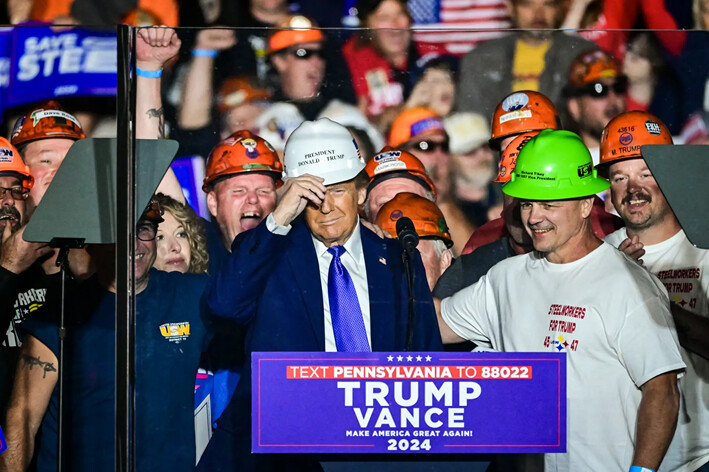 Miembros de «Steelworkers for Trump» regalan al candidato republicano a la presidencia, el expresidente Donald Trump, un casco durante un mitin de campaña en el Aeropuerto Regional Arnold Palmer de Latrobe, Pensilvania, el 19 de octubre de 2024. (Jim Watson/AFP vía Getty Images)