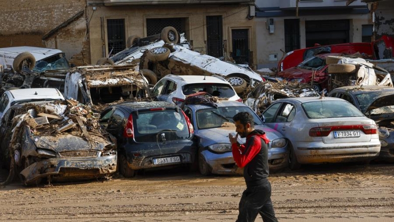 Un hombre camina junto a los coches apilados en Catarroja, Valencia (España) el 5 de noviembre de 2024, una de las localidades más afectados por las inundaciones. EFE/ Chema Moya