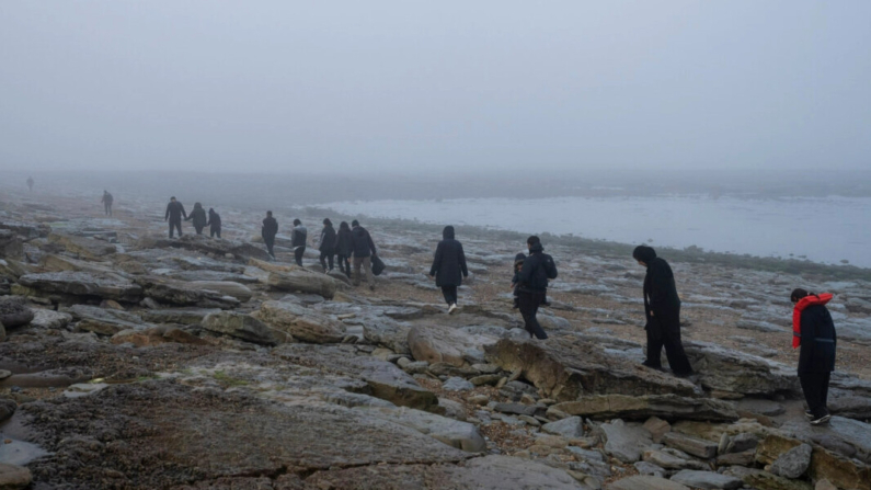 Un grupo de migrantes kurdos de Irán e Irak que fracasaron en su intento de llegar al Reino Unido en barco caminan de regreso a la ciudad de Ambleteuse, en Francia, el 19 de mayo de 2024. (Bernat Armangue/AP)