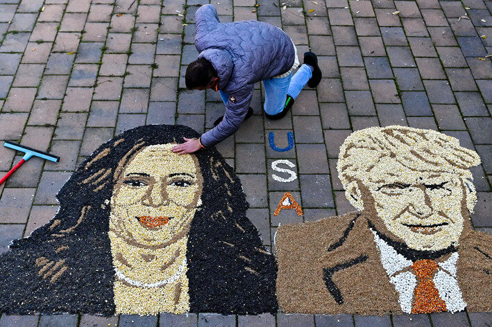 El artista kosovar Alkent Pozhegu trabaja en los toques finales de un mosaico de granos y semillas que representa el retrato de la candidata presidencial demócrata, Kamala Harris, y el candidato presidencial republicano, Donald Trump, en la ciudad de Gjakova, Kosovo, el 5 de noviembre de 2024. (Armend Nimani/AFP vía Getty Images)