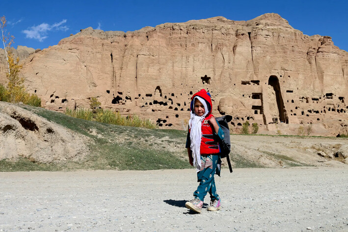 Una niña afgana pasa junto a las estatuas de los "Budas de Bamiyán", que fueron destruidas por los talibanes en 2001, en Bamiyán, Afganistán, el 5 de noviembre de 2024. (Mohammad Faisal Naweed/AFP vía Getty Images)