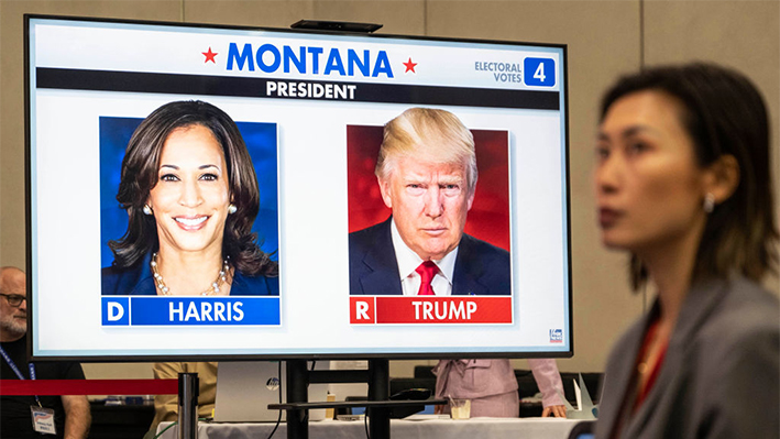 El candidato republicano y expresidente Donald Trump y la candidata demócrata y vicepresidenta Kamala Harris aparecen en una pantalla en una watch party de las elecciones en la embajada de Estados Unidos el 6 de noviembre de 2024 en Beijing, China. (Kevin Frayer/Getty Images)