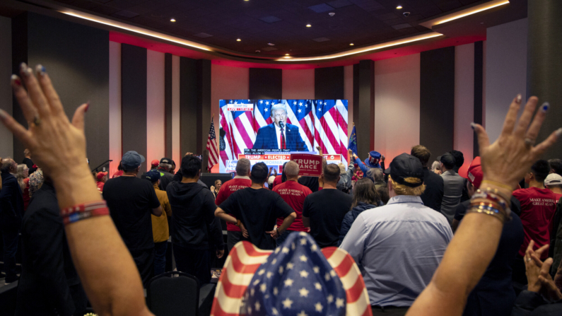 Los asistentes aplauden mientras se muestra en una pantalla una transmisión del ex presidente de EE. UU. y candidato presidencial republicano Donald Trump hablando en su fiesta electoral en Florida, durante la fiesta de observación de elecciones del Partido Republicano de Nevada en Las Vegas, Nevada, el 6 de noviembre de 2024. (RONDA CHURCHILL/AFP via Getty Images)