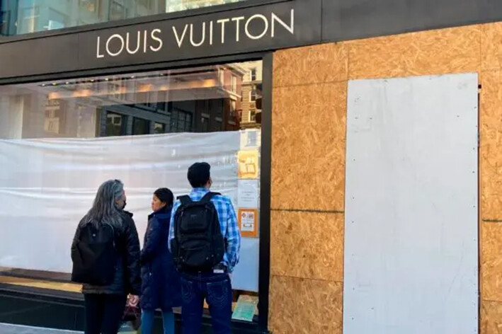 Visitantes de Union Square observan los daños en una tienda de Louis Vuitton en San Francisco, el 21 de noviembre de 2021. (Danielle Echeverria/San Francisco Chronicle vía AP)