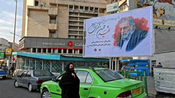 Una mujer camina junto a una valla publicitaria en honor al científico nuclear asesinado Mohsen Fakhrizadeh en la capital iraní, Teherán, el 30 de noviembre de 2020. (Atta Kenare/AFP vía Getty Images)