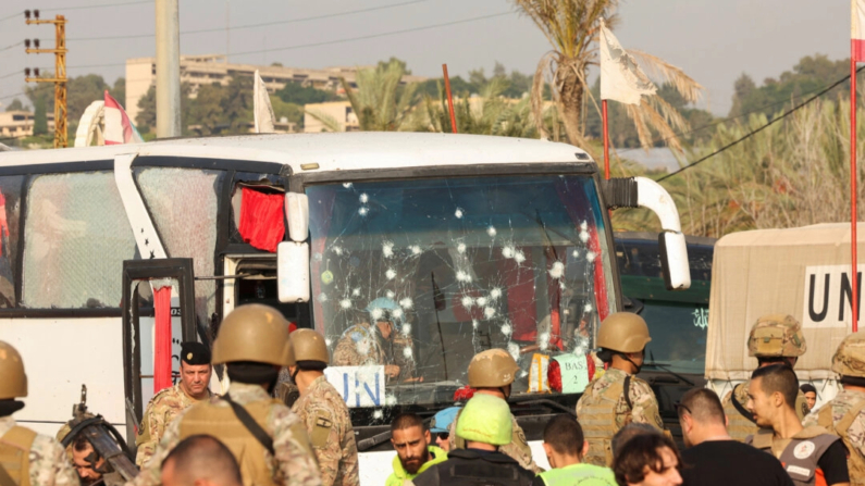 Un grupo de personas junto a un autobús de la ONU dañado tras un ataque israelí a la entrada de Sidón, Líbano, el 7 de noviembre de 2024. (Aziz Taher/Reuters)