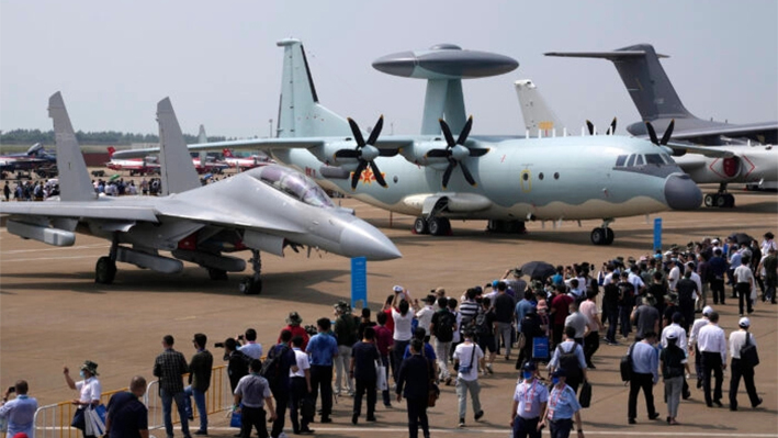 Visitantes observan el avión militar chino de guerra electrónica J-16D (izq.) y el avión de alerta temprana y control aerotransportado KJ-500 (der.) durante la 13ª Exposición Internacional de Aviación y Aeroespacial de China en Zhuhai, provincia china de Guangdong, el 29 de septiembre de 2021. (Ng Han Guan/Foto AP)