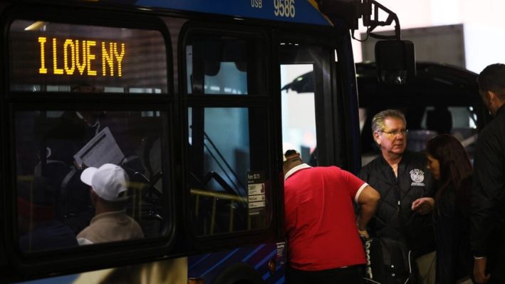 Inmigrantes ilegales abordan un autobús rumbo a un refugio en la terminal de autobuses de la Autoridad Portuaria en la ciudad de Nueva York, el 18 de mayo de 2023. (Michael M. Santiago/Getty Images)