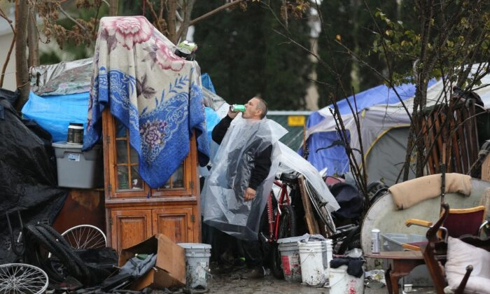 Un hombre bebe rápidamente en el campamento de personas sin hogar conocido como "The Jungle" en el Valle del Silicio, en San José, California, el 3 de diciembre de 2014. (Josh Edelson/AFP vía Getty Images)