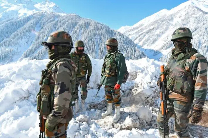 Soldados del ejército indio en una carretera cubierta de nieve cerca del paso de montaña de Zojila, que conecta Srinagar con el territorio de la unión de Ladakh, fronterizo con China, el 28 de febrero de 2021. (Tauseef Mustafa/AFP vía Getty Images)