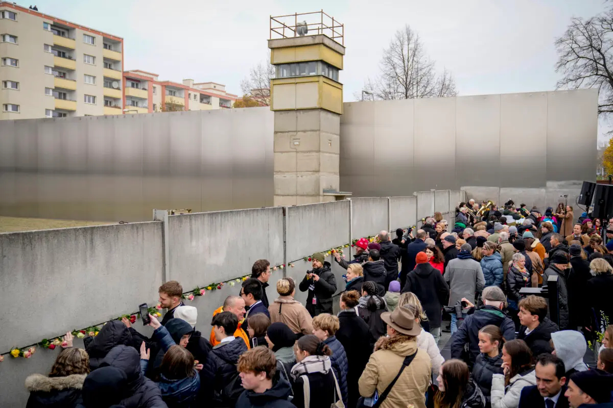 Un grupo de personas asiste a una ceremonia de colocación de flores con motivo del 35 aniversario del Muro en los terrenos del Memorial del Muro de Berlín, Berlín, Alemania, el 9 de noviembre de 2024. (Ebrahim Noroozi/Foto AP)