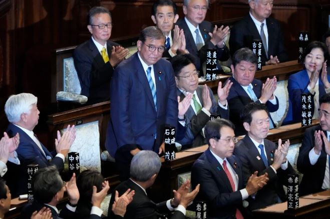 El primer ministro japonés Shigeru Ishiba (de pie) recibe aplausos tras ganar una votación para elegir un nuevo primer ministro en una sesión parlamentaria especial de la cámara baja en Tokio el 11 de noviembre de 2024. (AP Photo/Eugene Hoshiko)