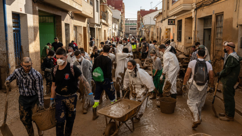 Voluntarios y residentes limpian el barro de la calle mientras el área se recupera de las inundaciones generalizadas de la semana pasada el 9 de noviembre de 2024 en el municipio de Massanassa Valencia, España. (David Ramos/Getty Images)