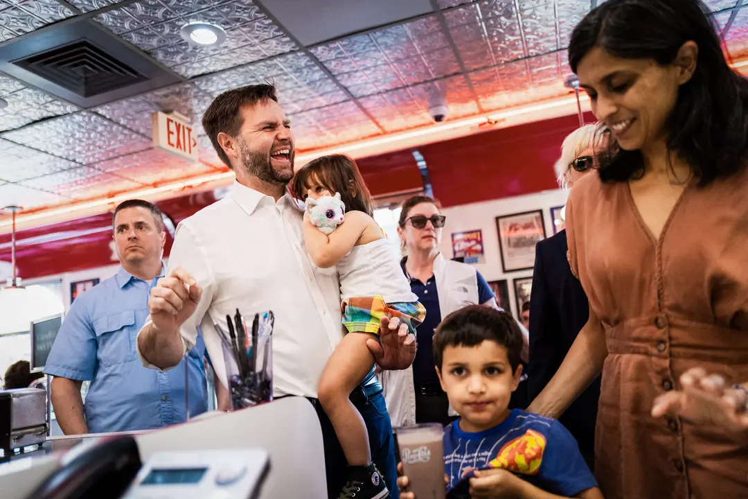 El candidato republicano a la vicepresidencia, el senador JD Vance (R-Ohio), lleva en brazos a su hija Maribel Vance mientras llega con su esposa Usha Vance para saludar a sus seguidores en el Park Diner de St Cloud, Minnesota, el 28 de julio de 2024. (Stephen Maturen/Getty Images)