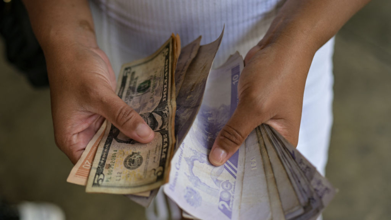 Una mujer cuenta billetes de bolívares y dólares estadounidenses en el barrio de Petare en Caracas (Venezuela) el 24 de julio de 2024. (Yuri Cortez/AFP vía Getty Images)