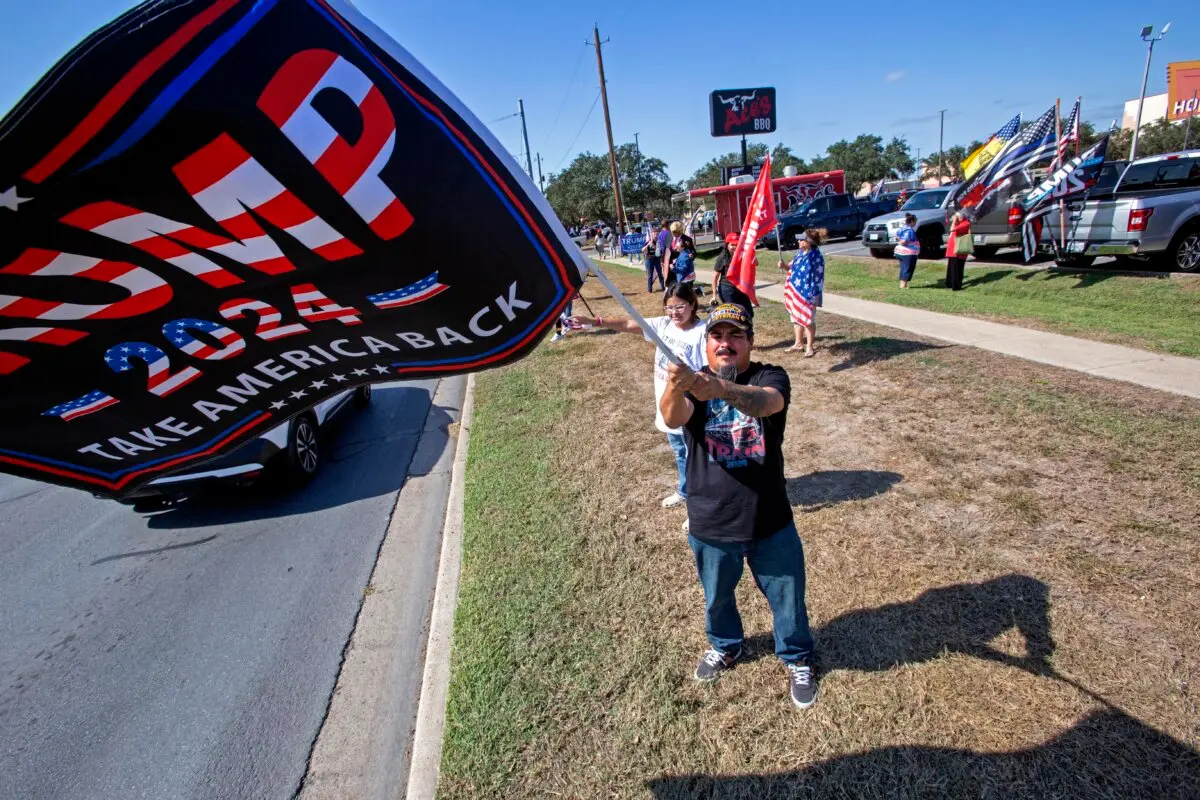 El veterano del ejército Félix Cano, de 42 años, de Weslaco, agita una bandera de Trump en McAllen, Texas, el 9 de noviembre de 2024. (Bobby Sanchez/The Epoch Times)