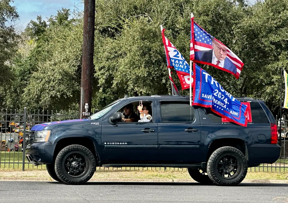 Una simpatizante de Trump usa su teléfono para grabar en video la larga fila de coches detrás de ella que participaron en un mitin de Trump en McAllen, Texas, el 9 de noviembre de 2024. (Darlene McCormick Sanchez/The Epoch Times)