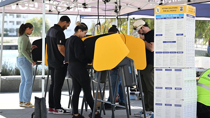 Varias personas depositan su voto en un centro de votación móvil al aire libre en el estadio SoFi de Los Ángeles el día de las elecciones, el 5 de noviembre de 2024. (Robyn Beck/AFP vía Getty Images)