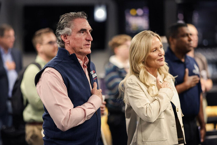 El candidato republicano a la presidencia de Dakota del Norte, el gobernador Doug Burgum, y su esposa Kathryn Burgum recitan el juramento a la bandera durante una parada de campaña en Ankeny, Iowa, el 9 de junio de 2023. (Scott Olson/Getty Images)