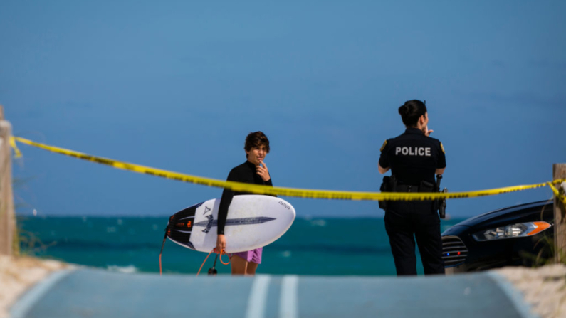 Un oficial de policía habla con un niño en playa en South Beach, Florida, el 19 de marzo de 2020. (Eva Marie Uzcategui/AFP vía Getty Images)