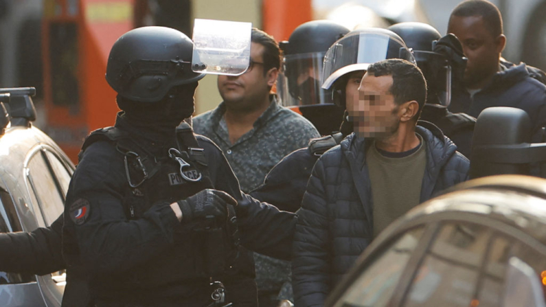 Un rehén es acompañado por un policía tras ser liberado del restaurante "Pizza L'Olivier" en Issy-les-Moulineaux, a las afueras de París, el 16 de noviembre de 2024. (Ian Langsdon/AFP vía Getty Images)