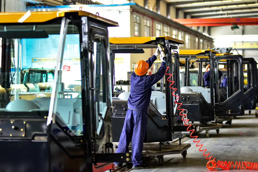 Trabajadores construyen cabinas para excavadoras en una fábrica de Qingzhou, provincia china de Shandong, el 31 de octubre de 2024. (STR/AFP vía Getty Images)