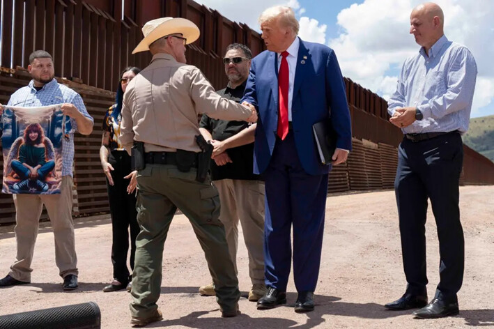 El sheriff del condado de Cochise, Mark Dannels, estrecha la mano del expresidente Donald Trump en la valla fronteriza entre Estados Unidos y México al sur de Sierra Vista, Arizona, el 22 de agosto de 2024. (Rebecca Noble/Getty Images)